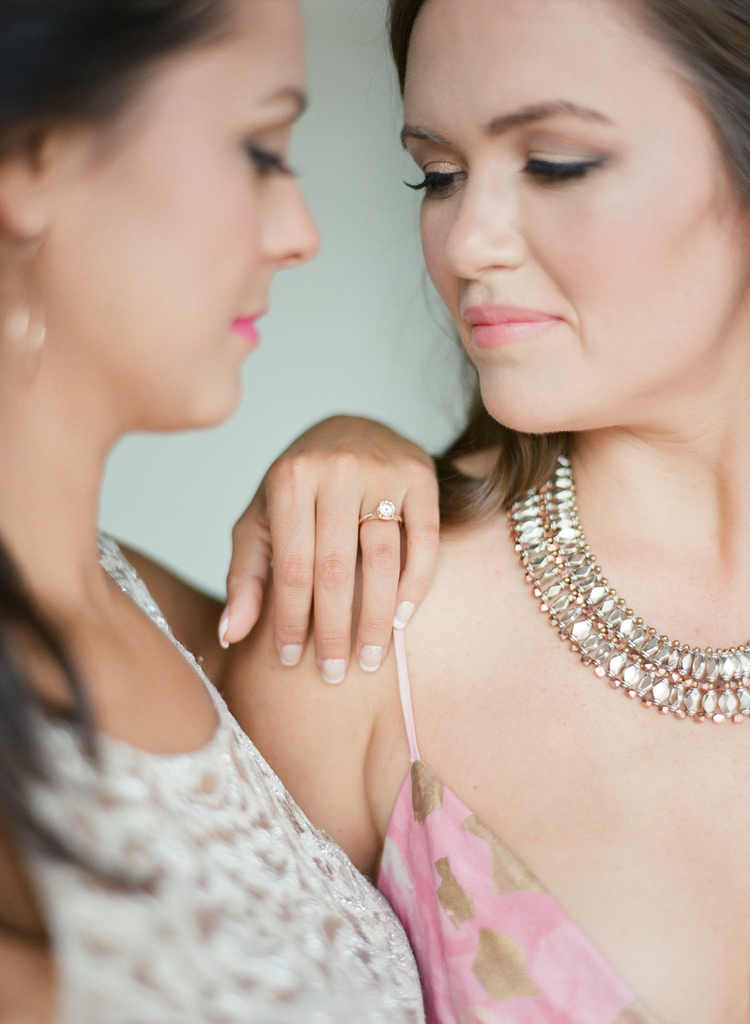 Brides looking at each other with delicate gold jewelry 