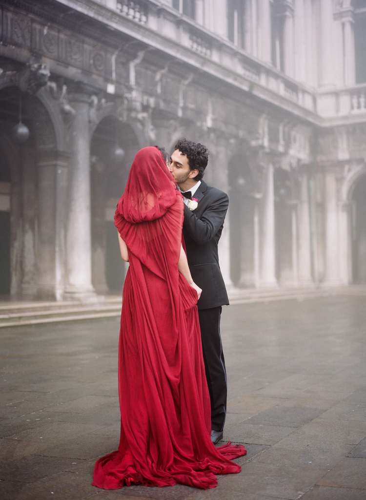 Bride and groom kiss in Piazza San Marco with beautiful architecture in the back 