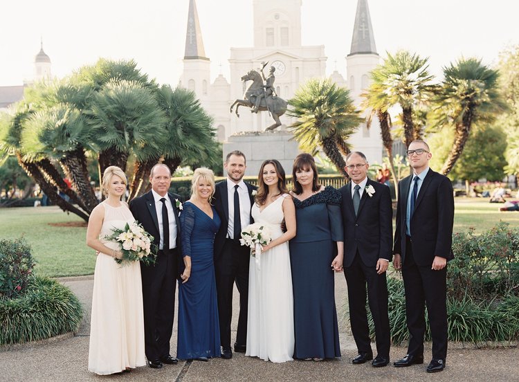 Wedding party and family pose for a picture in front of Jackson Square and the St. Louis Cathedral in New Orleans, LA