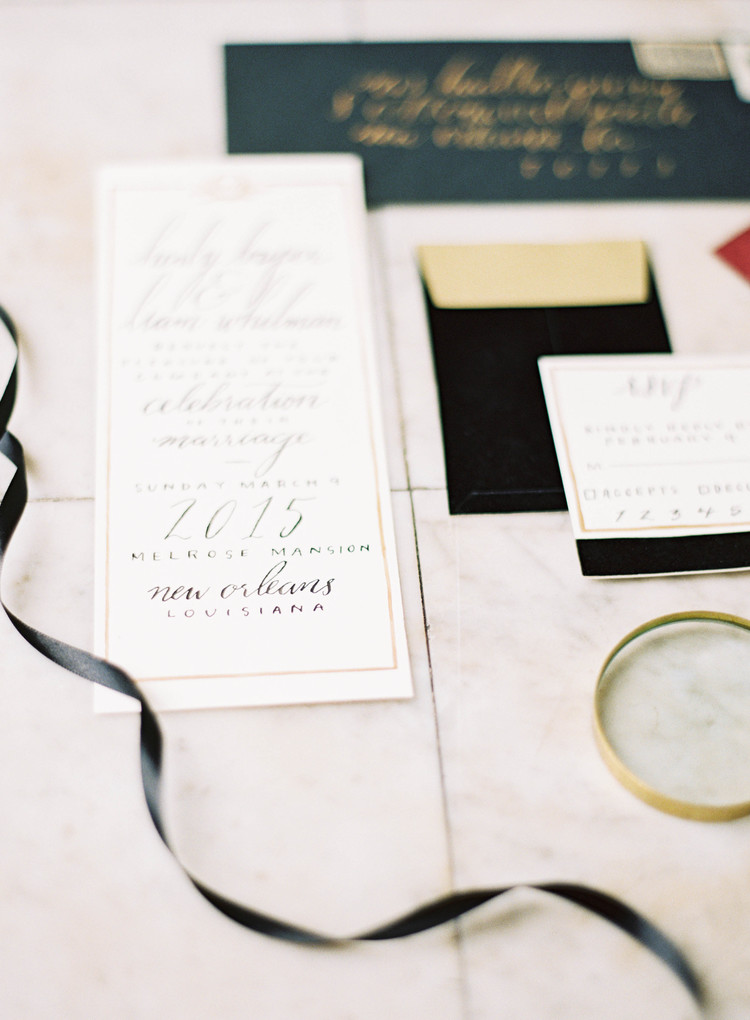 Delicate invitations with black writing and gold detailing 