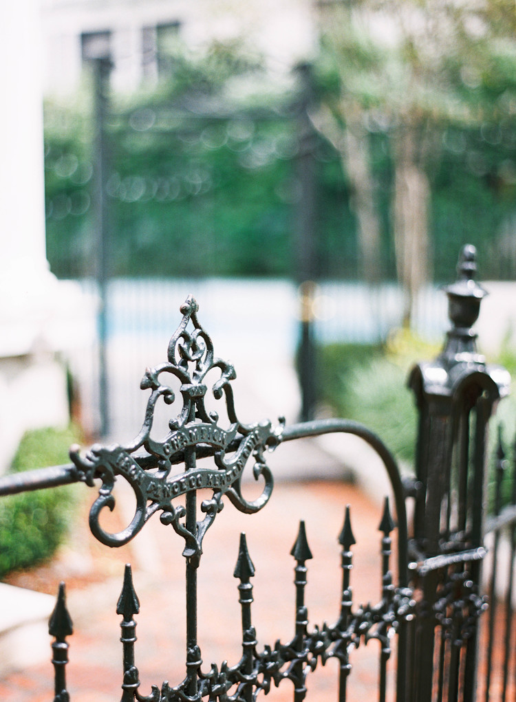 Up close photo of a rod iron fence with detailing 