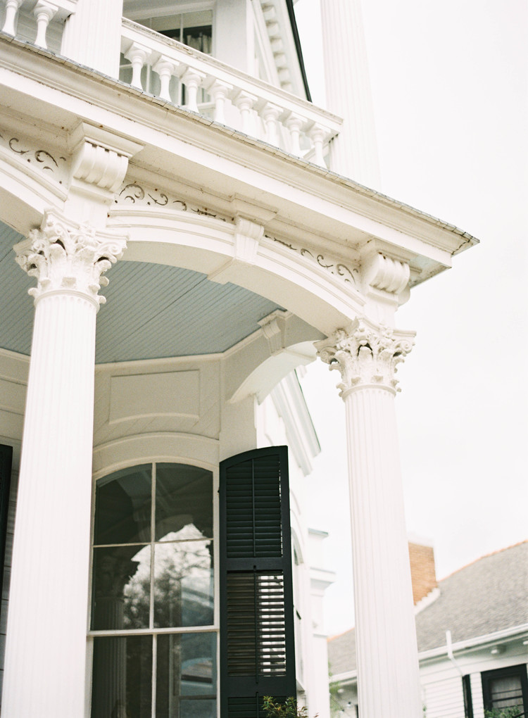 Gorgeous tall white columns with detailing at the top in front of a house 