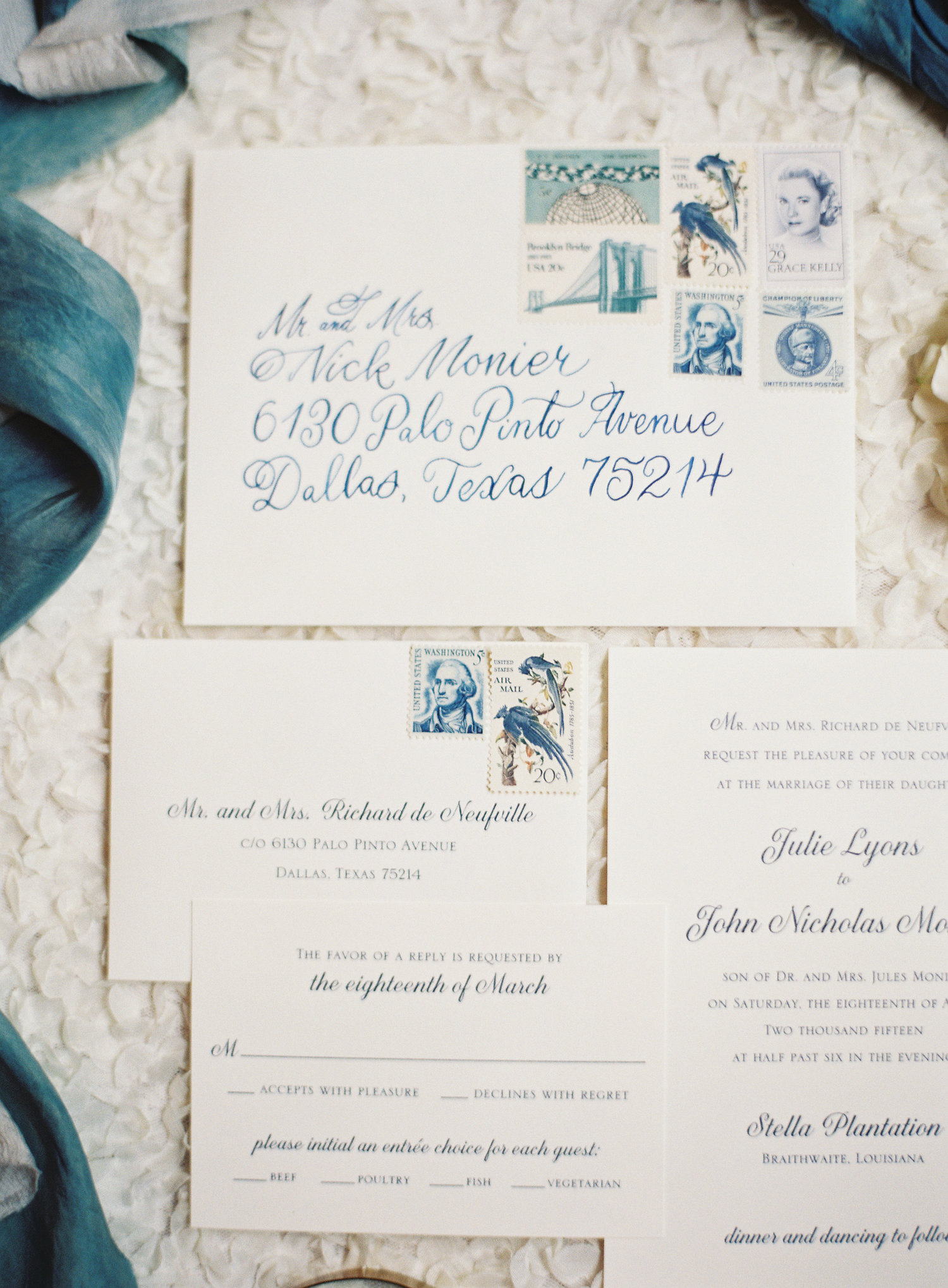 Ivory wedding invitation suite with blue calligraphy and a blue stamp story 