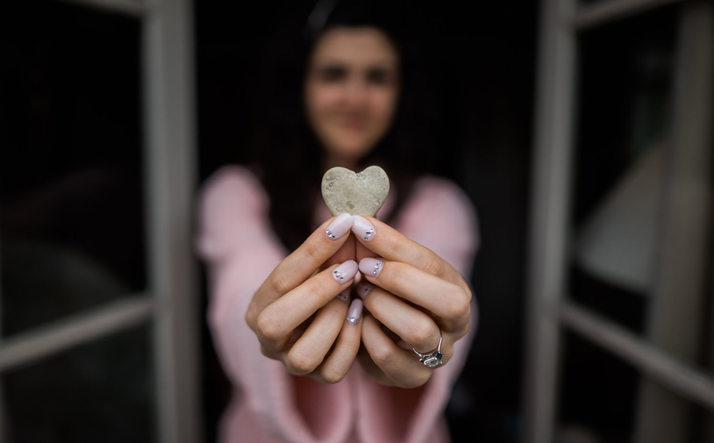 Bride holding a heart shaped rock while in her pink gown 