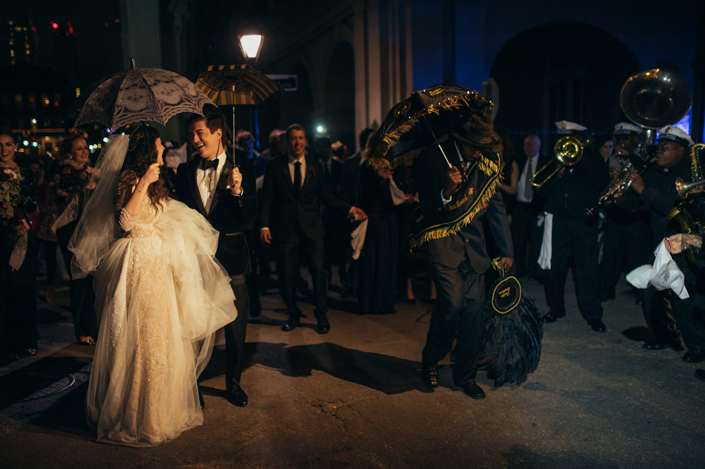 Bride and groom dancing to a traditional New Orleans second line with umbrellas and hanker-chiefs 