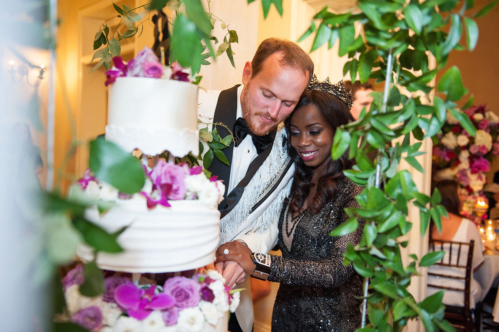 bride and groom cutting wedding cake together at wedding reception